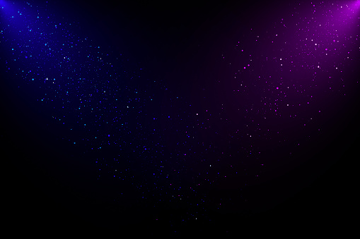 Two spot lights blue and purple coming from the up corners with twinkling glitter over black background.
