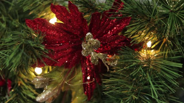 Christmas poinsettia decoration with glitter in pine garland needles.