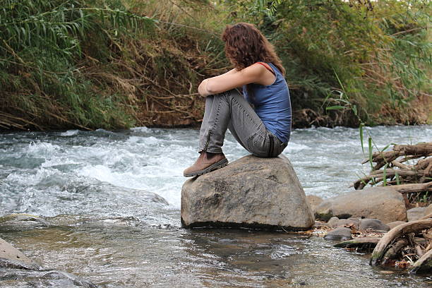 istock Young woman hiker sitting on a rock 187287238