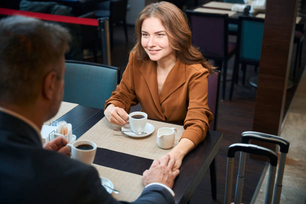 istock Elegant man and woman drinking coffee at the table 1872876495