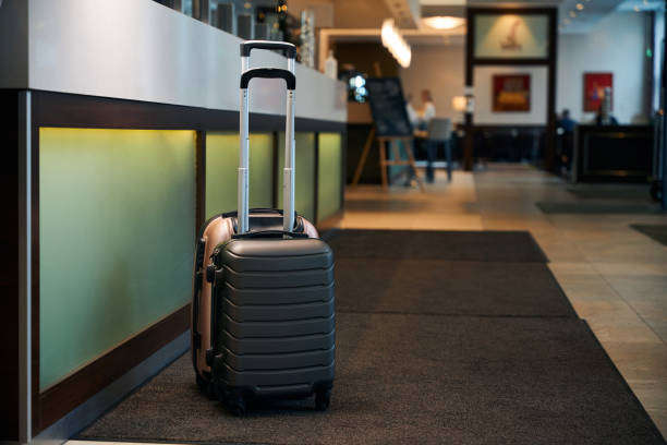 istock Two suitcases near reception desk in modern hotel lobby with lighting 1872877070