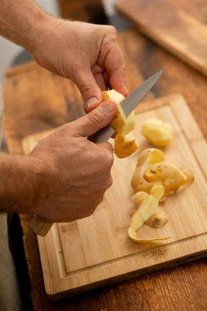 istock Chef peeling potatoes, preparing ingredients for cooking. 1872883905