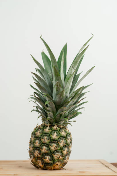 istock A whole pineapple on a wooden surface against a light background 1872884451