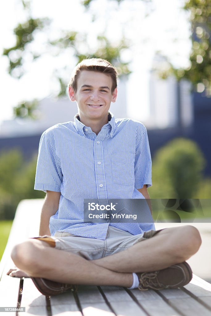 Glückliche junge Teen Boy sitzt im Freien auf der Terrasse im Innenhof Bank - Lizenzfrei Seersucker Stock-Foto