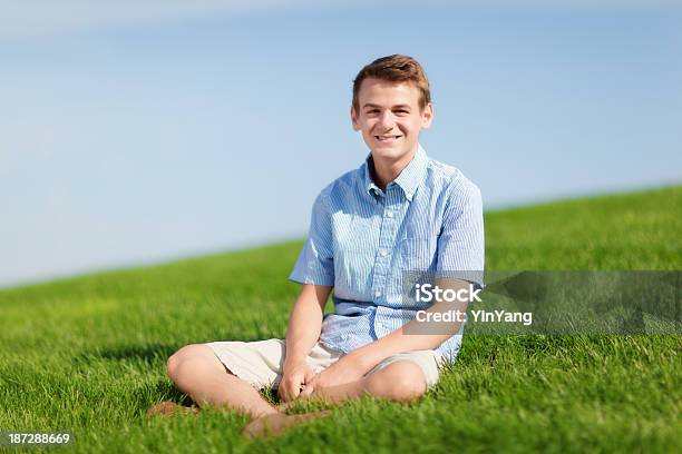 Foto de Feliz Sorrindo Jovem Sentado Ao Ar Livre Na Grama Meadow Slope e mais fotos de stock de Anarruga