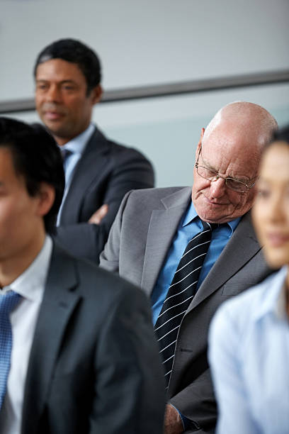 istock Senior businessman taking nap during seminar 187289801