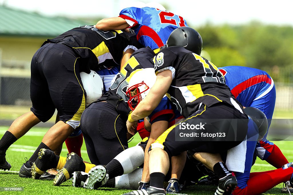 Sports: Défenseurs attaquer running back sur le terrain. - Photo de Ballon de football américain libre de droits