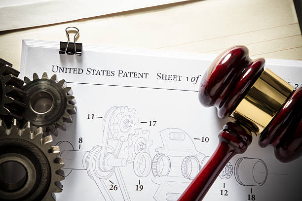 Patent Law - Mechanical Gavel next to gears and mechanical diagram for patent application.  Concept for patent attorney. patent stock pictures, royalty-free photos & images