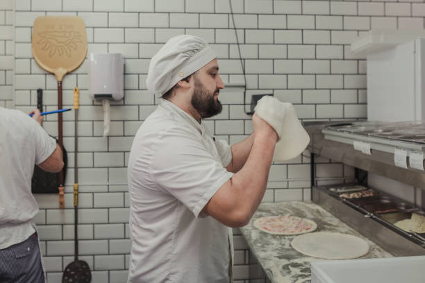 istock Man kneading a pizza dough in the air 1872919304