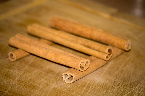 Cinnamon, cinnamon sticks on wooden background, chopper