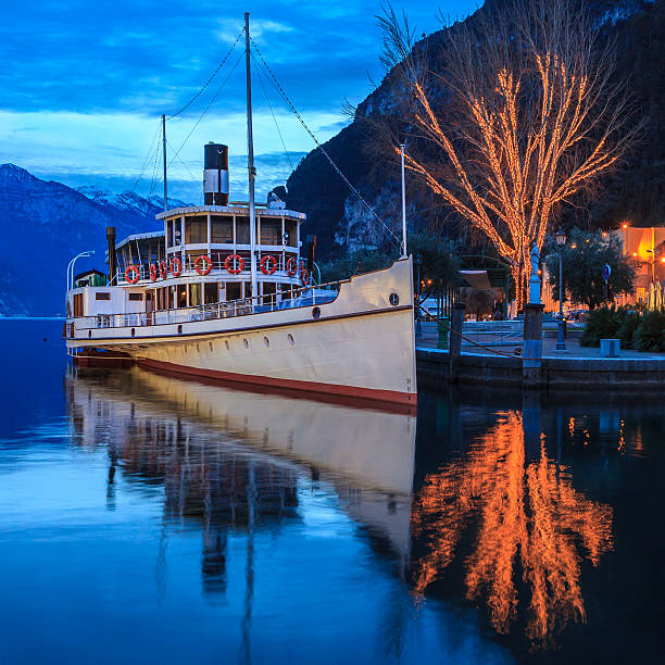 Ferry moored at Riva del Garda, one of the beautiful towns on the shore of the Lake Garda, the largest Italian lake. It is located on the northern side of the lake, in the Trentino-Alto Adige region. Italy.
