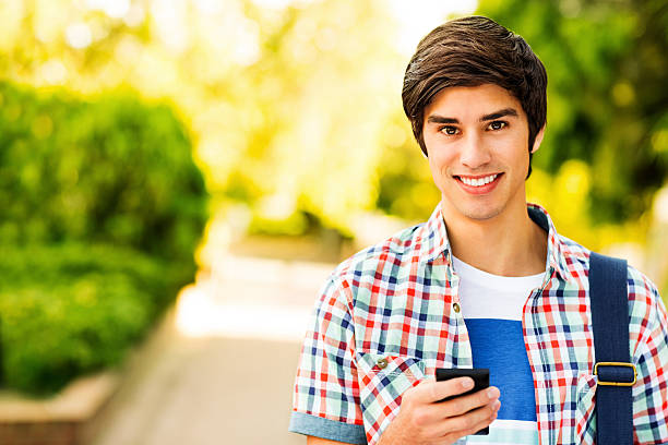 istock Male Student Holding Smart Phone On College Campus 187295876