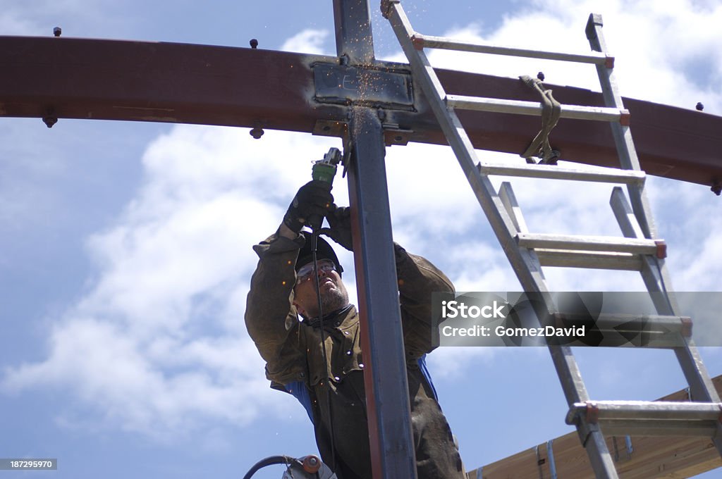 Un macho Soldador, sobre la escalera, trabajo con acero - Foto de stock de Ciudad libre de derechos