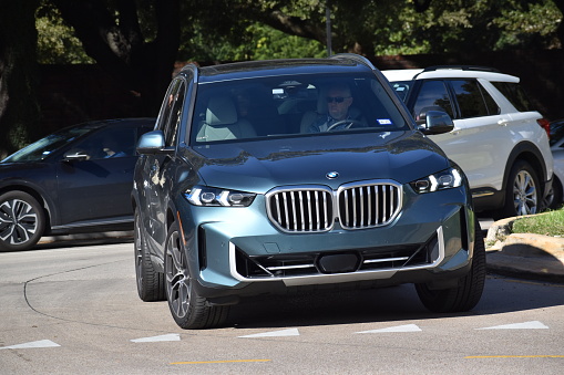 Houston, TX USA 10-1-2023 - A blue BMW SUV cruising near Herman Park in Houston