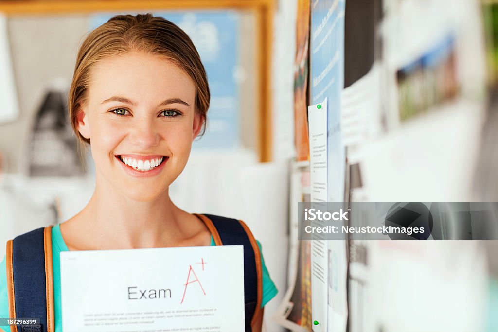 Chica mostrando examen informe con un grado en College - Foto de stock de Universidad libre de derechos