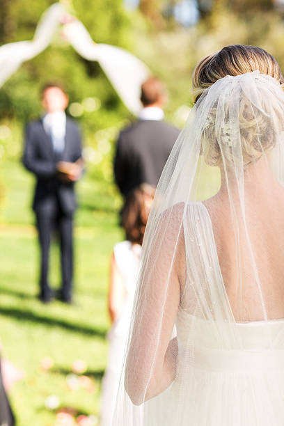 istock Bride Wearing Veil Walking Down The Aisle During Garden Wedding 187296631