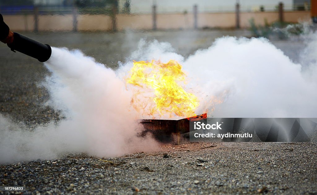 A fireman extinguishing a fire Firefighting. Fire Extinguisher Stock Photo