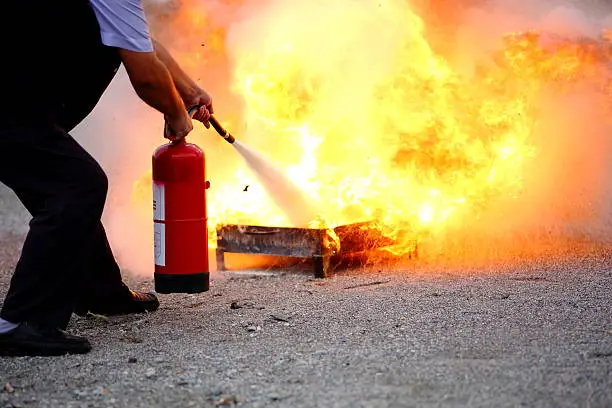 Man puts out fire with extinguisher.