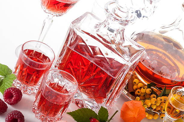 Rapsberry and rowanberry liqueurs Glasses and carafes with liqueurs with rapsberries and rowanberries nalewka stock pictures, royalty-free photos & images