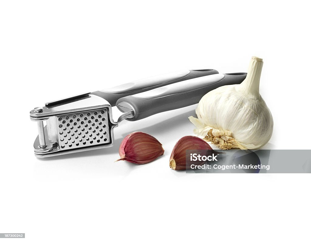 Garlic Crusher High quality image from my Kitchen Essentials Series of a stainless steel garlic clove crusher against a white background. Copy space. Clove - Spice Stock Photo