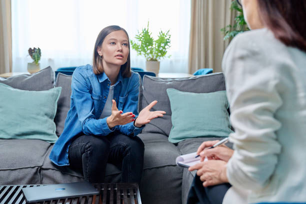 istock Sad young woman at therapy session with psychologist 1873007976
