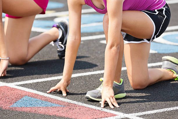 istock High school athletes at starting line on track before race 187304823
