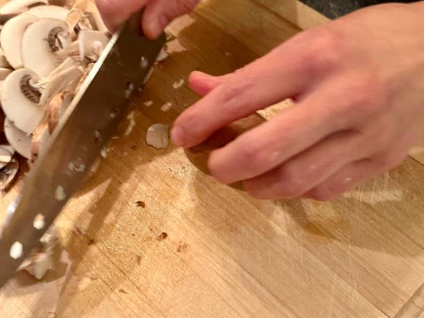 istock Cutting mushrooms to slices on wooden curring board 1873052999