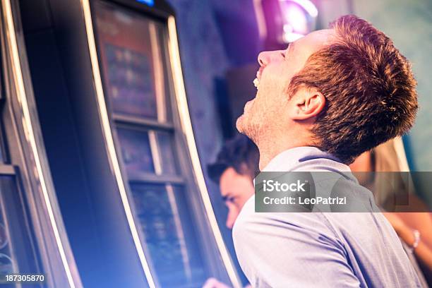 Junger Mann Spielen Am Spielautomaten Stockfoto und mehr Bilder von Spielautomat - Spielautomat, Gewinnen, Bildhintergrund
