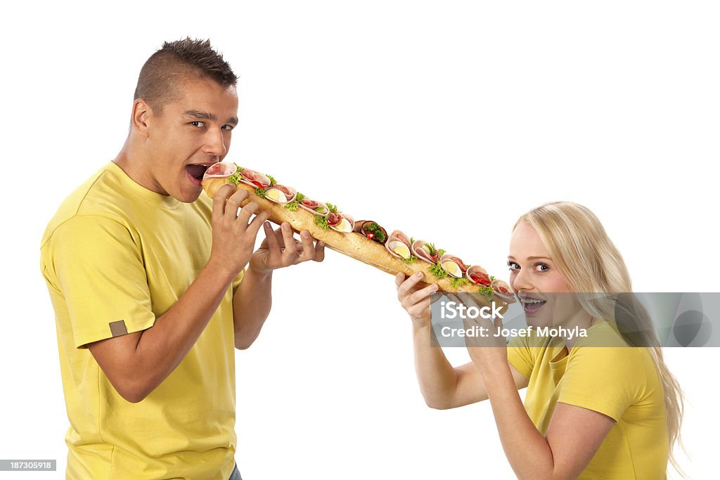 Giovane uomo e donna mangiare Panino grande insieme - Foto stock royalty-free di 18-19 anni