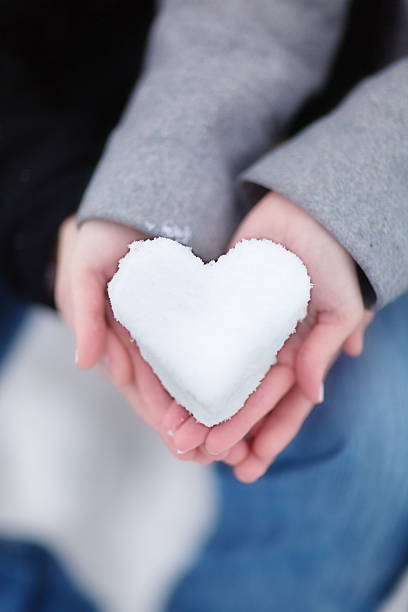 istock Romantic Couple Holding Heart made with Winter Snow Vertical 187306178