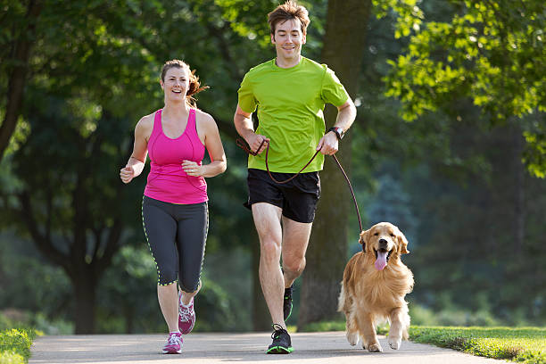 istock Golden Retriever , Man and Woman Jogging on a Paved Path. 187306539