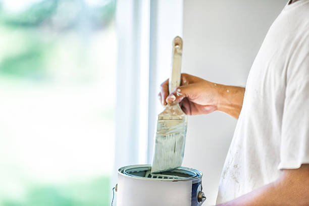 Painter dipping his brush in paint can A house painter dips his brush into a can of paint.  rr jodijacobson stock pictures, royalty-free photos & images