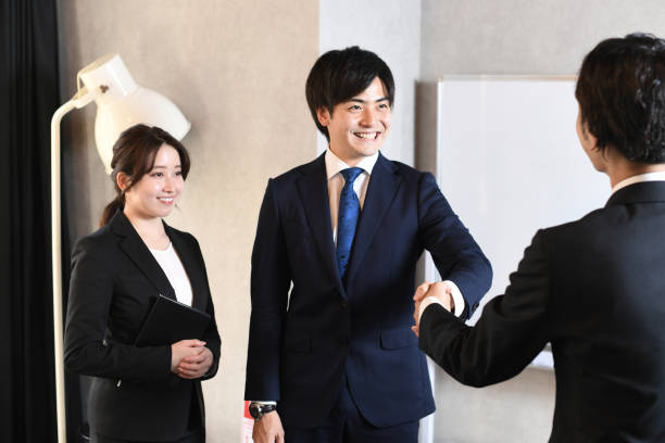 istock Asian businessman shaking hands and secretary looking on 1873099983