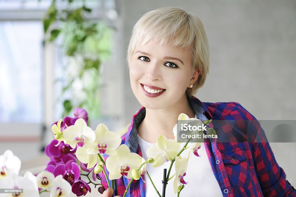 girl with orchids cheerful girl with orchids in a greenhouse Adult Stock Photo