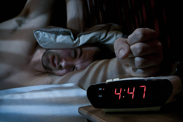 Unhappy man smashing the alarm clock. stock photo
