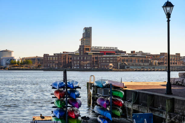 Baltimore, Maryland - December 12, 2023: View of the Baltimore waterfront including the Under Armour Headquarters from Fells Point. Colorful Kayaks are stacked in the foreground.