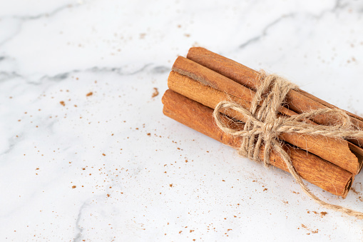 Cinnamon sticks and powder isolated on white background. Close-up. Healthy antioxidant aromatic spice for baking and seasoning.