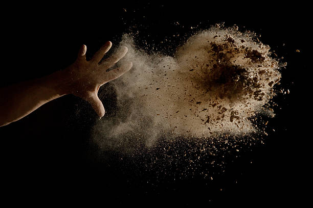 Throwing a Handful of brown earth in the air stock photo