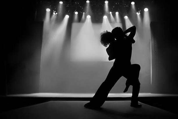 Couple in silhouette dancing on a stage stock photo