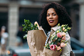 Joyful Shopping Spree: Radiant Woman with Groceries and Flowers