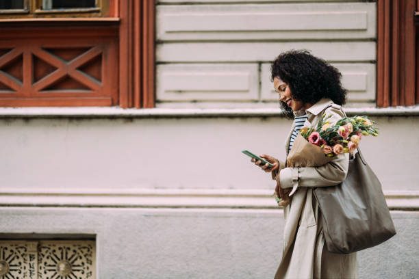 istock On-the-Go: Happy Shopper Multitasking with Mobile and Bags 1873163225