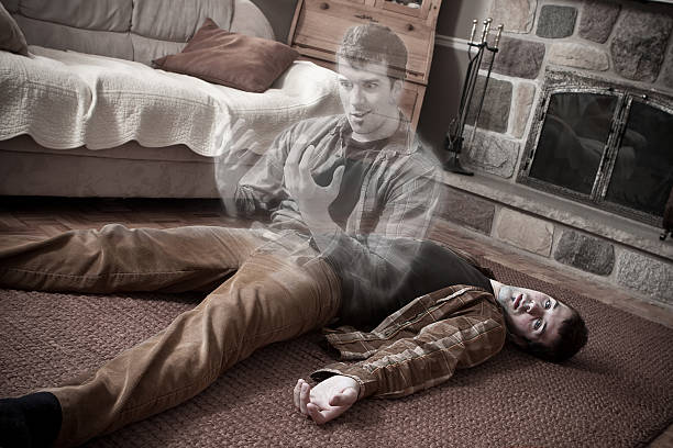 Happy soul leaving a corpse lying on the floor stock photo