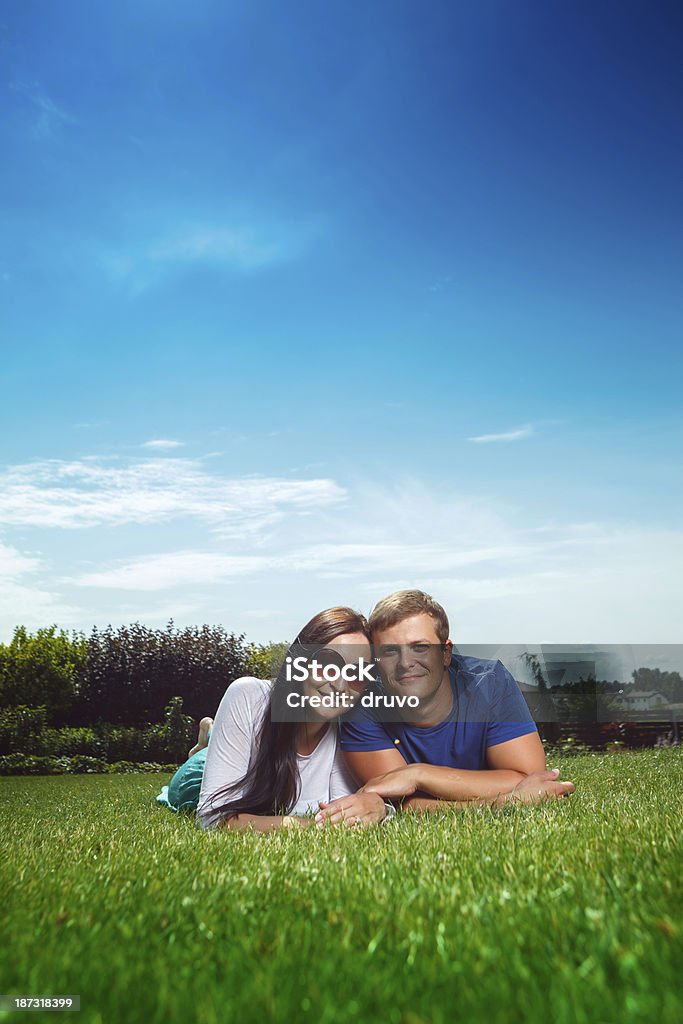 Heureux jeune couple allongé sur l'herbe - Photo de 25-29 ans libre de droits