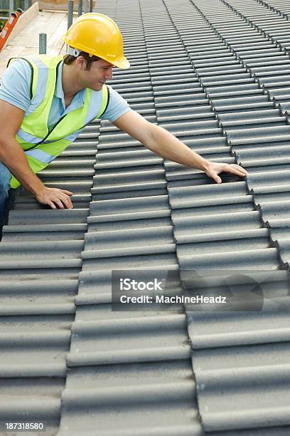 Builder Inspecting The Roof Of New Building On A Cloudy Day Stock Photo - Download Image Now