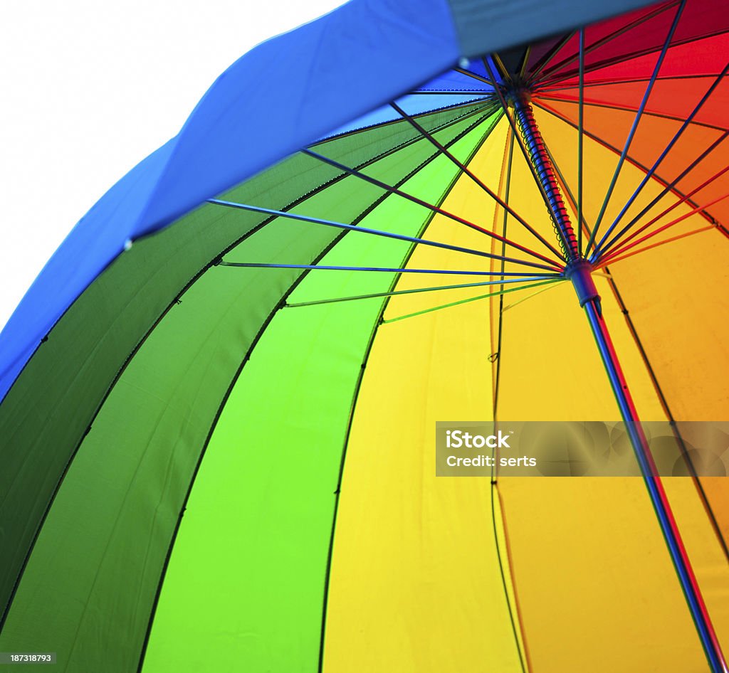 Under Colorful Umbrella Under an rainbow colored umbrella on white background. Beach Umbrella Stock Photo