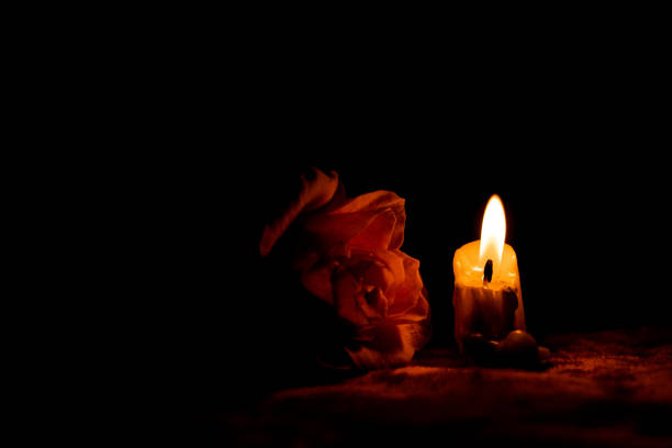 istock Candle flame and rose in the dark, mourning and sadness 1873197687