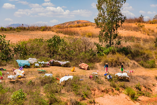 Antsirabe, Madagascar 19 october 2023. Road from Morondava to Antsirabe through empty grassland and village in central Madagascar. women dry washed clothes on bushes