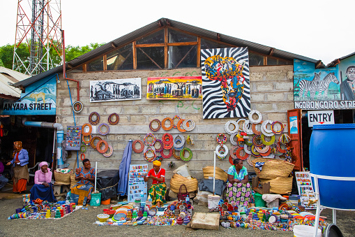 Arusha,Tanzania, Africa.02 february 2022. African masks, beaded bracelets, necklaces, Tanzanian bags woven from natural material displayed for sale at Masai market. Calendars and tourism theme