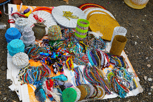 Arusha,Tanzania, Africa.02 february 2022. African masks, beaded bracelets, necklaces, Tanzanian national clothes, bags woven from natural material displayed and ready for sale. Calendars and tourism