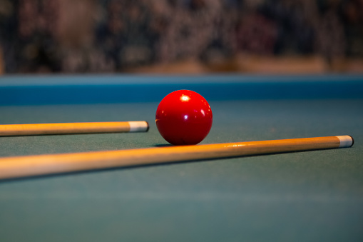 Billiard red ball on green table with billiard cue, Snooker, Pool game. Billiards pool table retro vintage style. Vintage billiard table in the interior. Billiards in retro style